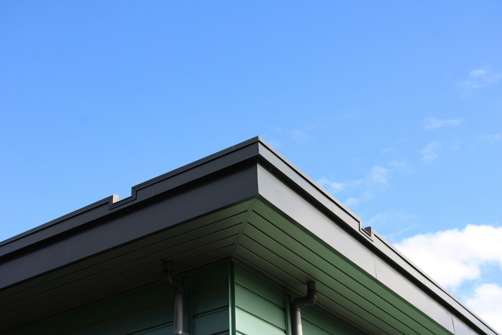 Modern building corner against a bright blue sky